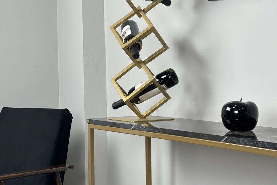 Metalowy stojak na wino o geometrycznym kształcie na trzy butelki. Producent Sigma Design.