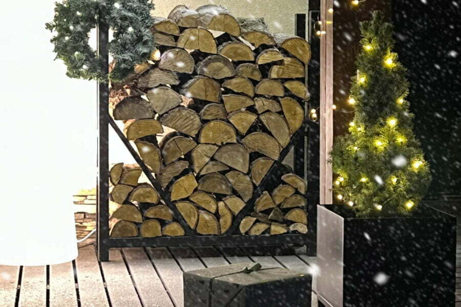 Stojak na drewno kominkowe na zimę stoi na tarasie.
